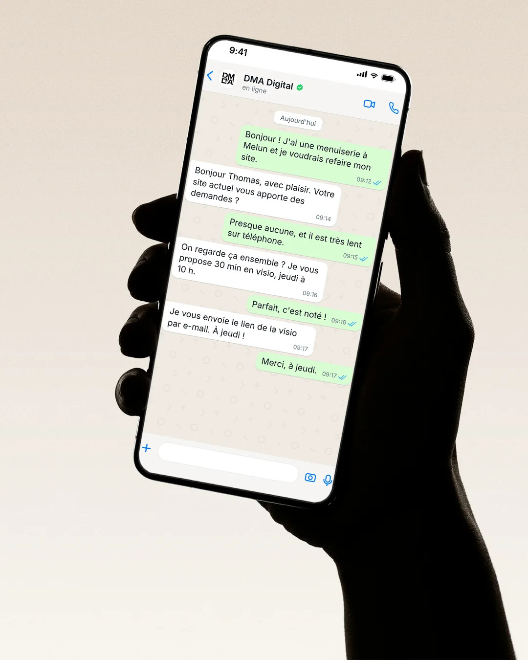 Une main tient un téléphone : conversation WhatsApp avec DMA Digital pour refaire un site