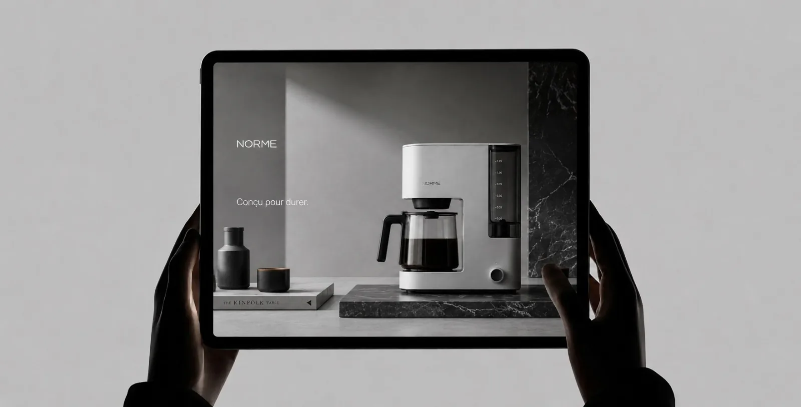Site vitrine d'une marque d'électroménager affiché sur une tablette tenue à deux mains