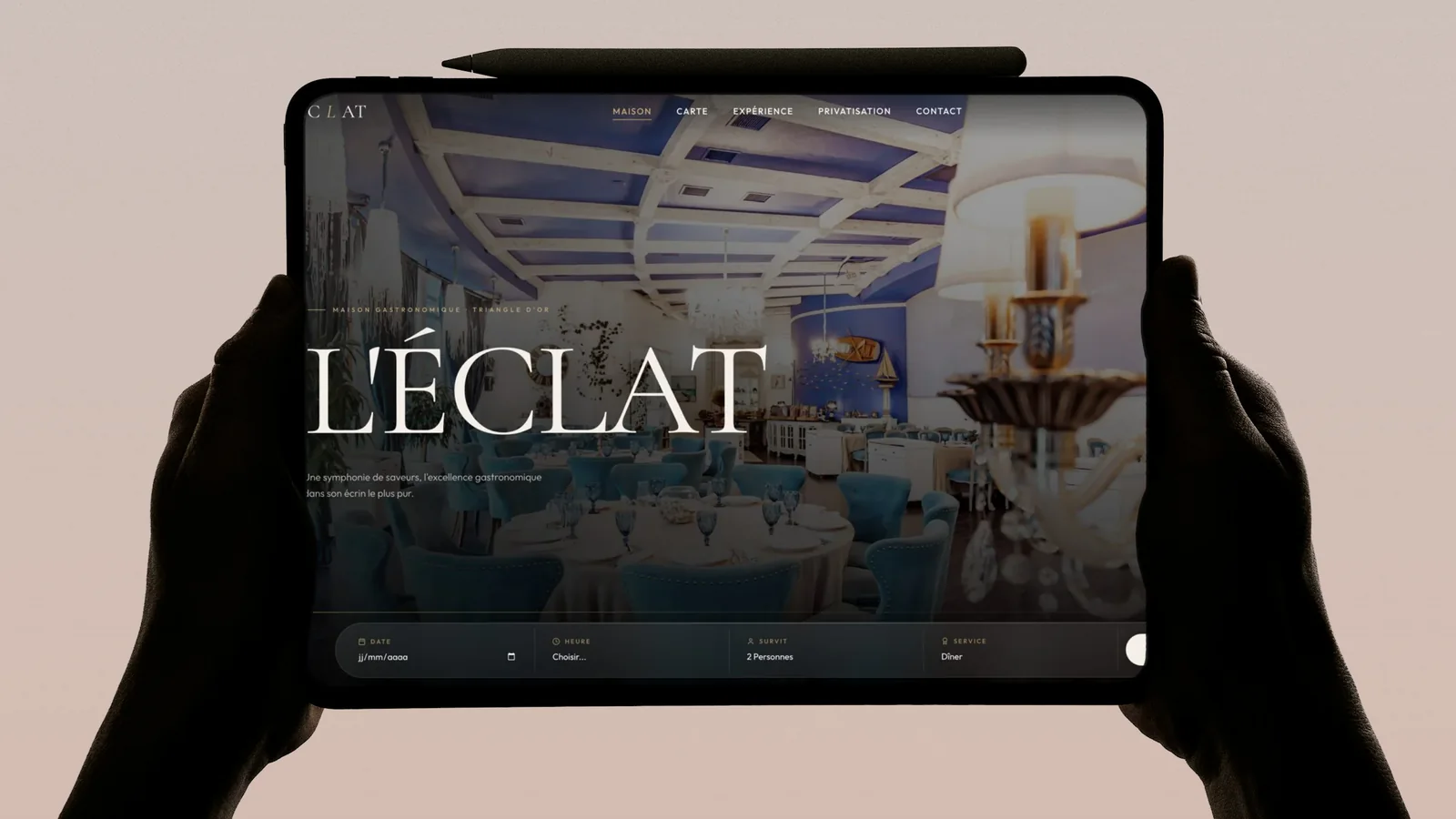 Page d'accueil d'un restaurant gastronomique affichée sur une tablette tenue à deux mains